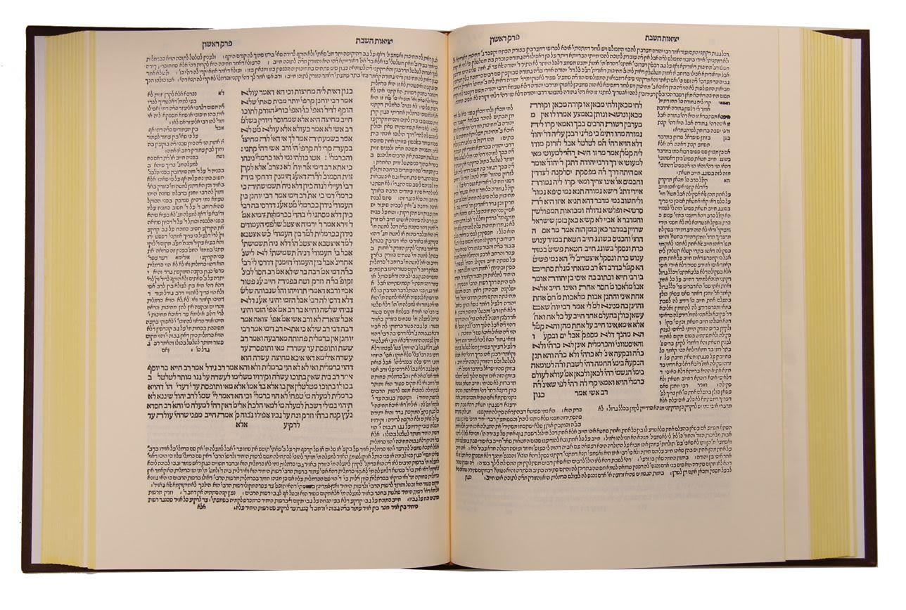An open Talmud volume: a central block of text framed on the inner and outer margins by two columns of smaller commentary type.