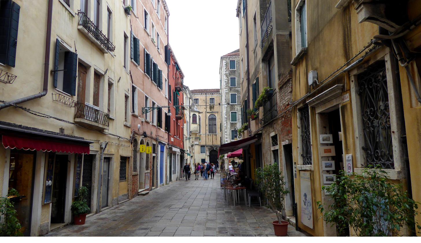 A narrow street in the Venetian Ghetto with tall multi-storey buildings