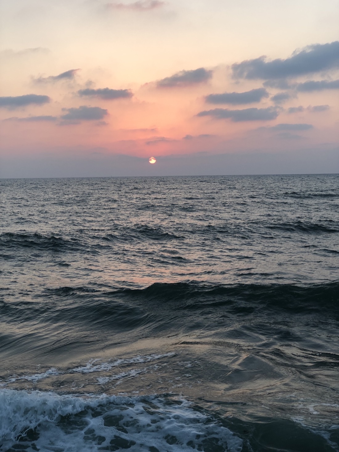 The Tel Aviv skyline along the Mediterranean coast at sunset.