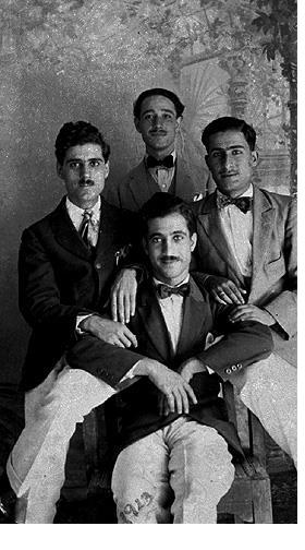 A 1923 studio portrait of four young Jewish men in suits and bow ties, Basra, Iraq.