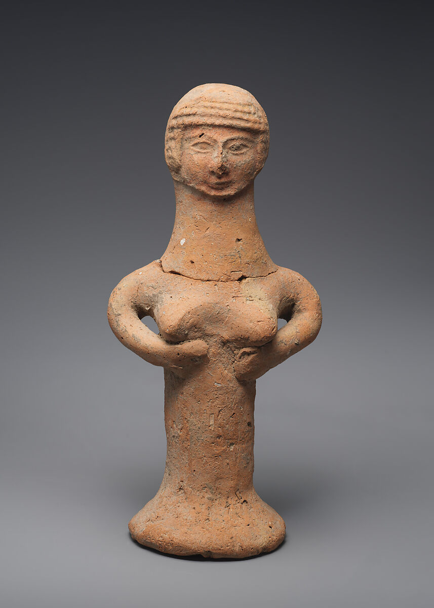 A small terracotta figurine of a woman: a mold-made head with banded curls, arms curving beneath full breasts, and a solid pillar body widening to a flat base.