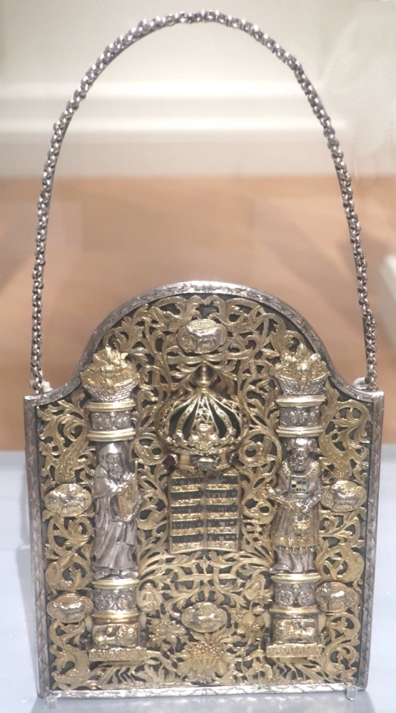 A gilded silver Torah shield with twin columns, two figures, and a crown over the Tablets of the Law