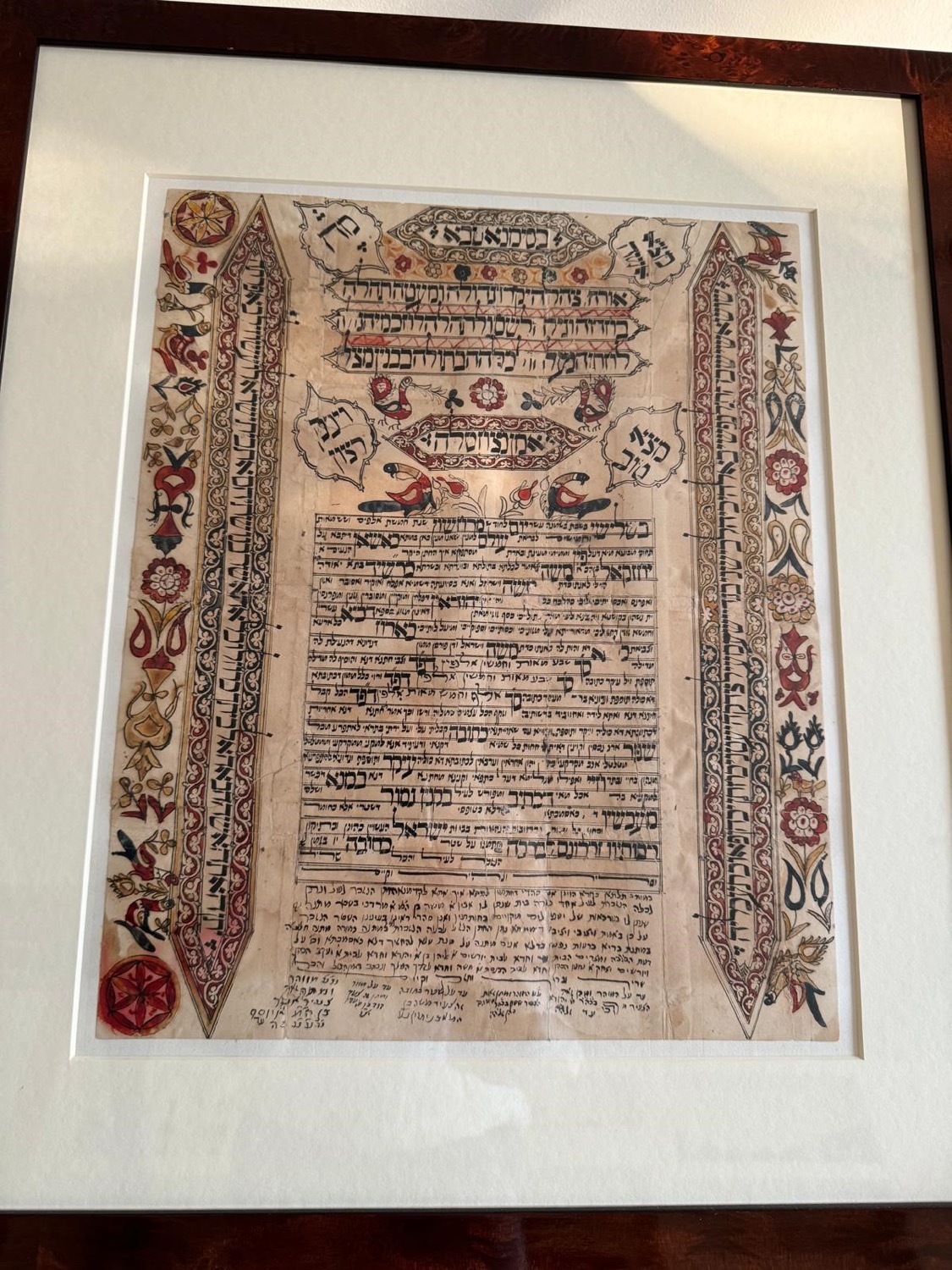 An illuminated Jewish marriage contract on paper, its text framed by painted decoration